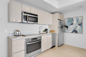 A modern kitchen with stainless steel appliances, a toaster, and a coffee maker. - Intracoastal View Apt | Private Balcony & Full Kitchen (Hallandale Beach)