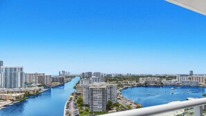 A high-rise building with a marina and waterway in the background. - Intracoastal View Apt | Private Balcony & Full Kitchen (Hallandale Beach)