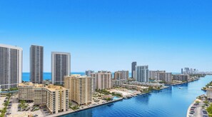 A coastal cityscape with high-rise buildings, a marina, and a clear blue sky. - Intracoastal View Apt | Private Balcony & Full Kitchen (Hallandale Beach)
