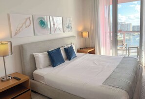 Ein Hotelzimmer mit einem Bett, zwei Nachttischen, einer Lampe und Kunstwerken an der Wand.