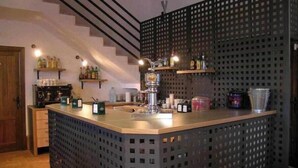 Een keuken met een bar, een trap en planken met flessen.