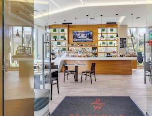 A modern bar area with a TV screen, wooden counter, and seating. - Premium Floor · 2BR · Intracoastal · Beachwalk (Hallandale Beach)