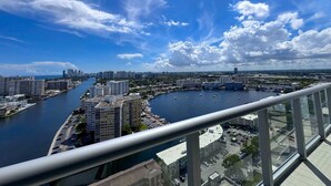 Een hoog gebouw met uitzicht op een jachthaven en stadsbeeld.