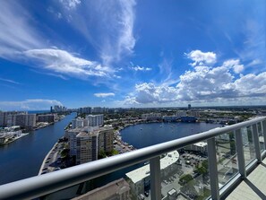 A high-rise building with a view of a marina and cityscape. - Intracoastal View Apt | Balcony & Resort Amenities (Hallandale Beach)