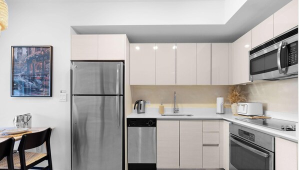 A modern kitchen with stainless steel appliances, a dishwasher, and a microwave. - Resort Living  2BR - Intracoastal View (Hallandale Beach)