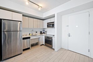 A modern kitchen with stainless steel appliances, a microwave, and a dishwasher. - Upper-Floor Bay View · 2BR Beachwalk Resort (Hallandale Beach)