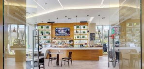 A modern bar area with a TV screen, wooden counter, and seating. - Spacious 1BR - Intracoastal View (Hallandale Beach)