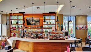 A modern bar with a curved counter, various liquor bottles, and a menu board. - Beachwalk Studio Intercoastal Balcony (Hallandale Beach)