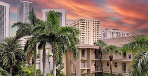 A multi-story building with balconies, surrounded by palm trees. - Beachwalk Studio | Intracoastal Balcony (Hallandale Beach)