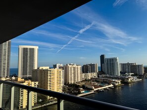 A high-rise building with a view of a marina and water. - Sunset View Apt | Pool, Gym & Beach Shuttle (Hallandale Beach)