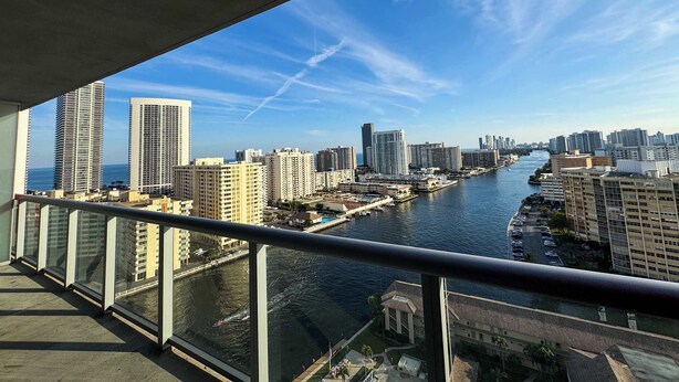 A high-rise building with a river view, modern architecture, and a clear sky. - Sunset View Condo · 2BR Beachwalk Resort (Hallandale Beach)