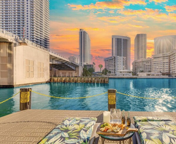 A waterfront hotel with high-rise buildings in the background, a swimming pool, and caution signs along the poolside. - Sunset View Condo · 2BR Beachwalk Resort (Hallandale Beach)