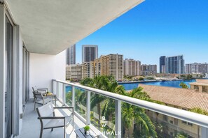 A balcony with a view of a city skyline and a marina. - Bright 1BR  Waterway View & Resort Lifestyle (Hallandale Beach)