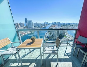A balcony with a view of a cityscape and a body of water. - Beachwalk Studio | Bay & Skyline Vistas (Hallandale Beach)