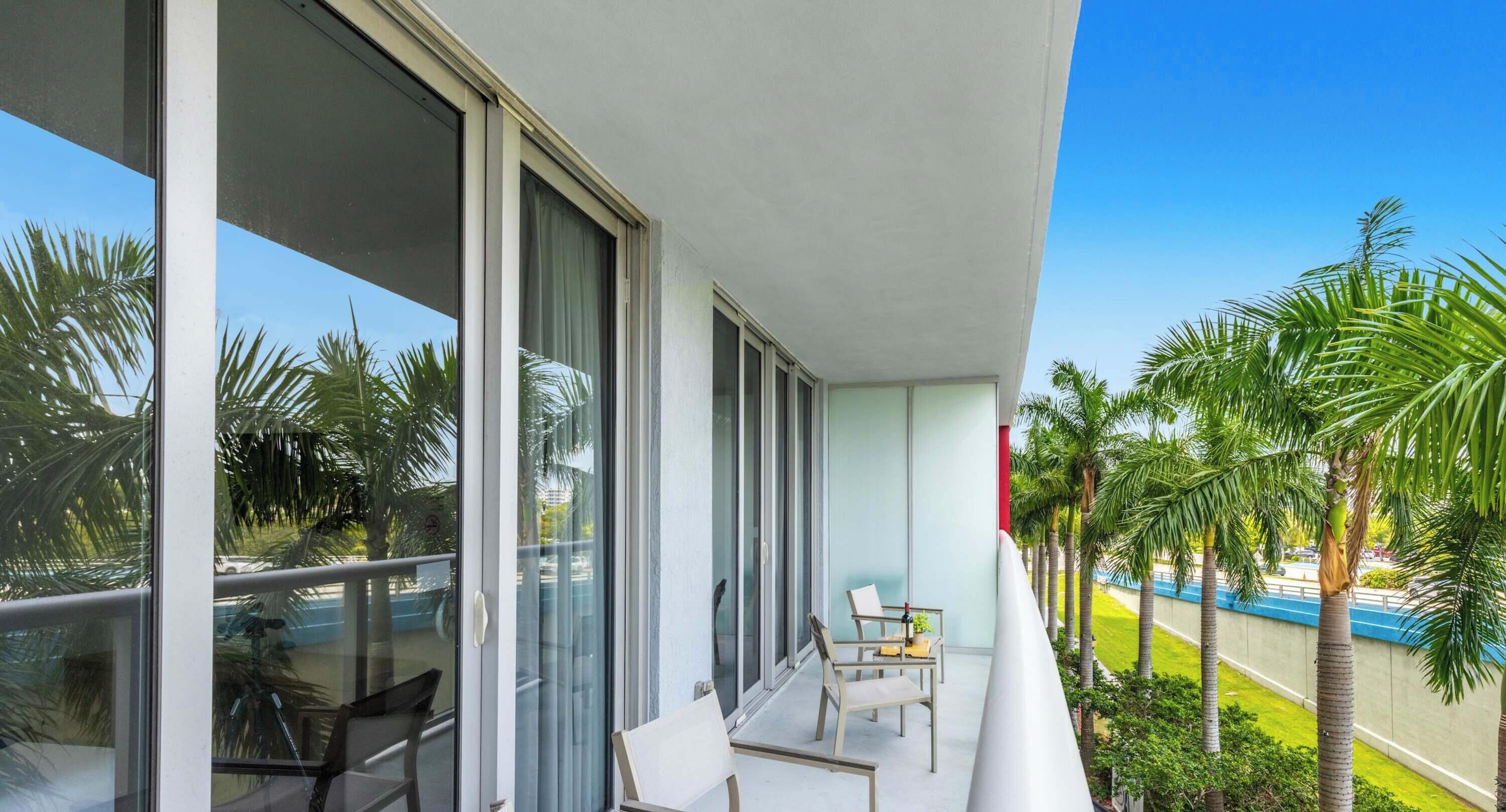 A balcony with a glass door, a chair, and a table.