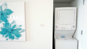 Ein Waschraum mit einer weißen Waschmaschine und einer an der Wand montierten Steckdose.