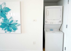 Ein Waschraum mit einer weißen Waschmaschine und einer an der Wand montierten Steckdose.