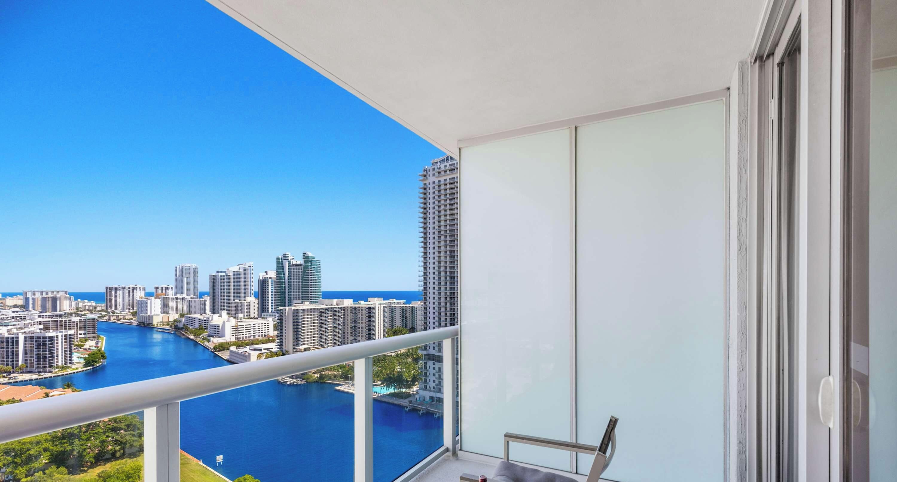 Un balcon offrant une vue sur les toits d’une ville et sur une rivière.