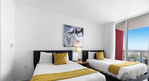 A hotel room with two beds, a large window, and a city view. - Resort Living 2BR · Bay View Hallandale (Hallandale Beach)
