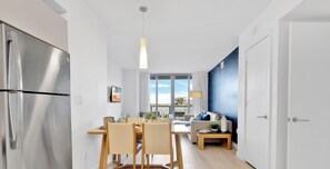 Eine moderne Küche mit Edelstahlkühlschrank, einem Holztisch und Stühlen.