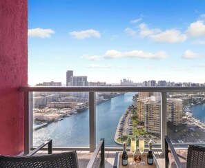 A high-rise building with a view of a river and marina. - Elevated Waterway 2BR · Beachwalk Resort (Hallandale Beach)
