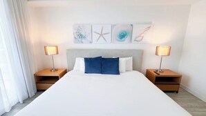 Una camera d'albergo con un letto grande, due comodini e opere d'arte alle pareti.