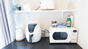 Een kitchenette met koffiezetapparaat, broodrooster en magnetron.