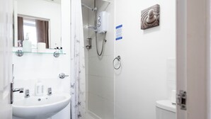 Een badkamer met wastafel, spiegel, douche en toilet.