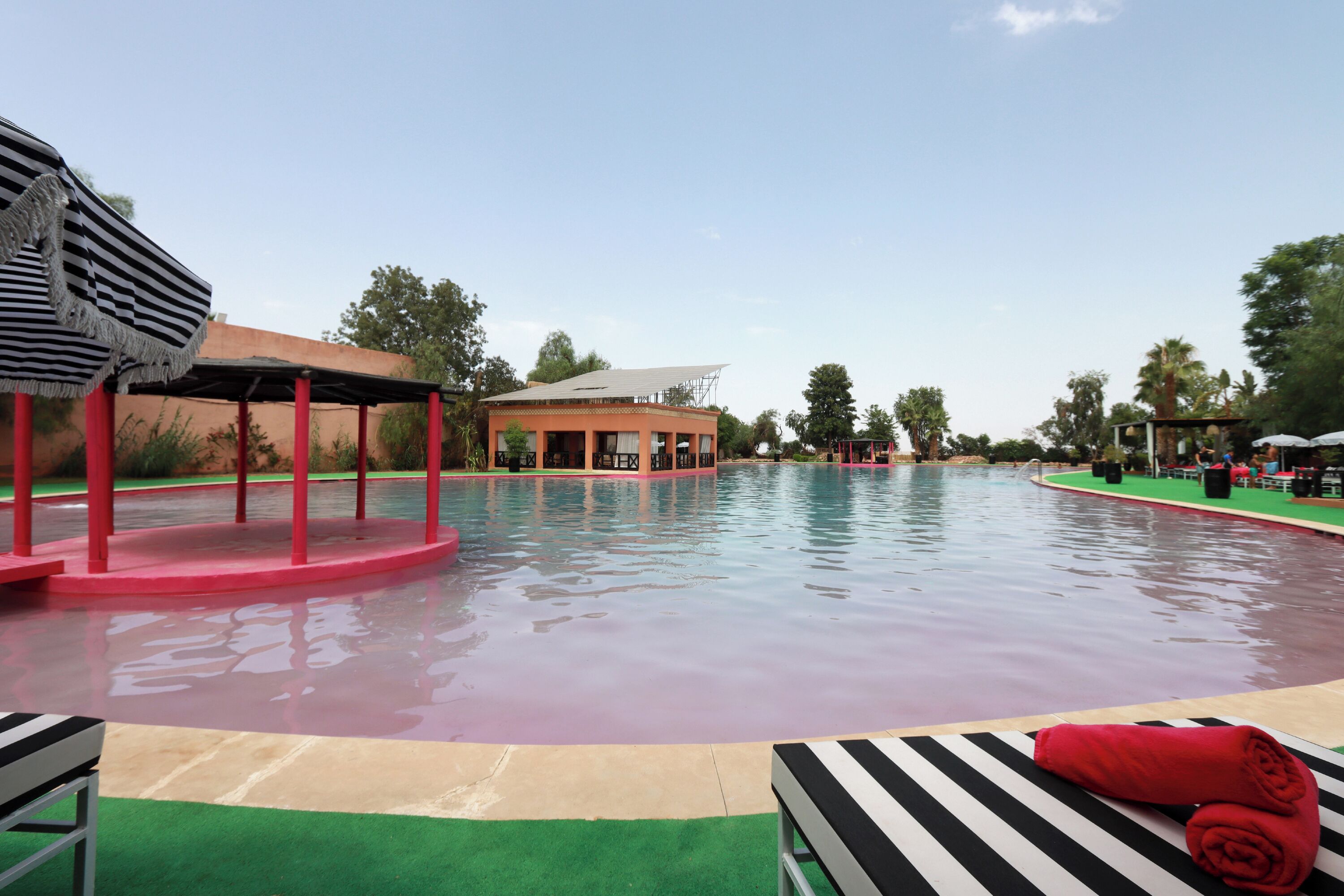 Una piscina con zona cubierta y sillas de descanso.