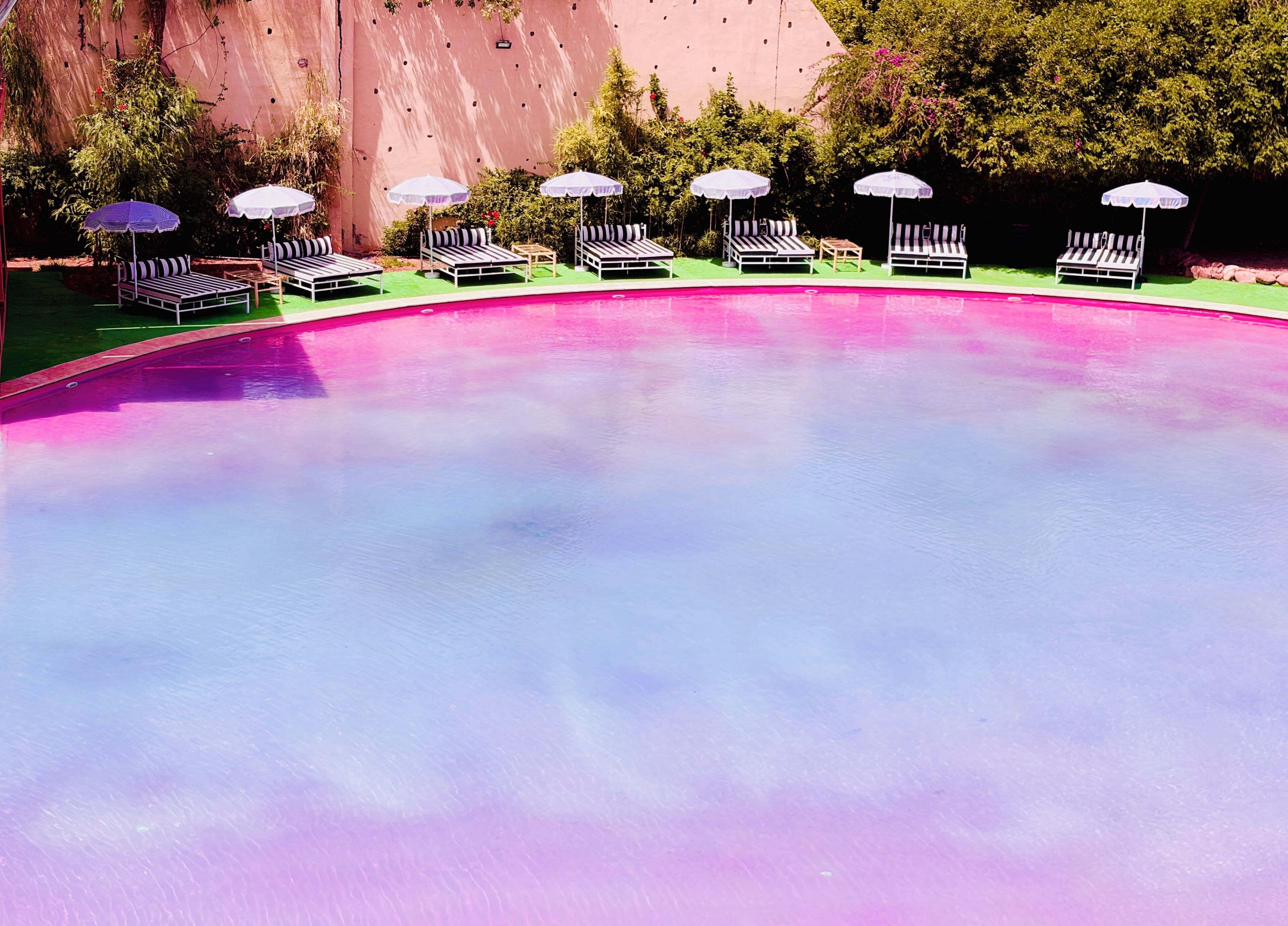 A swimming pool with lounge chairs and umbrellas.