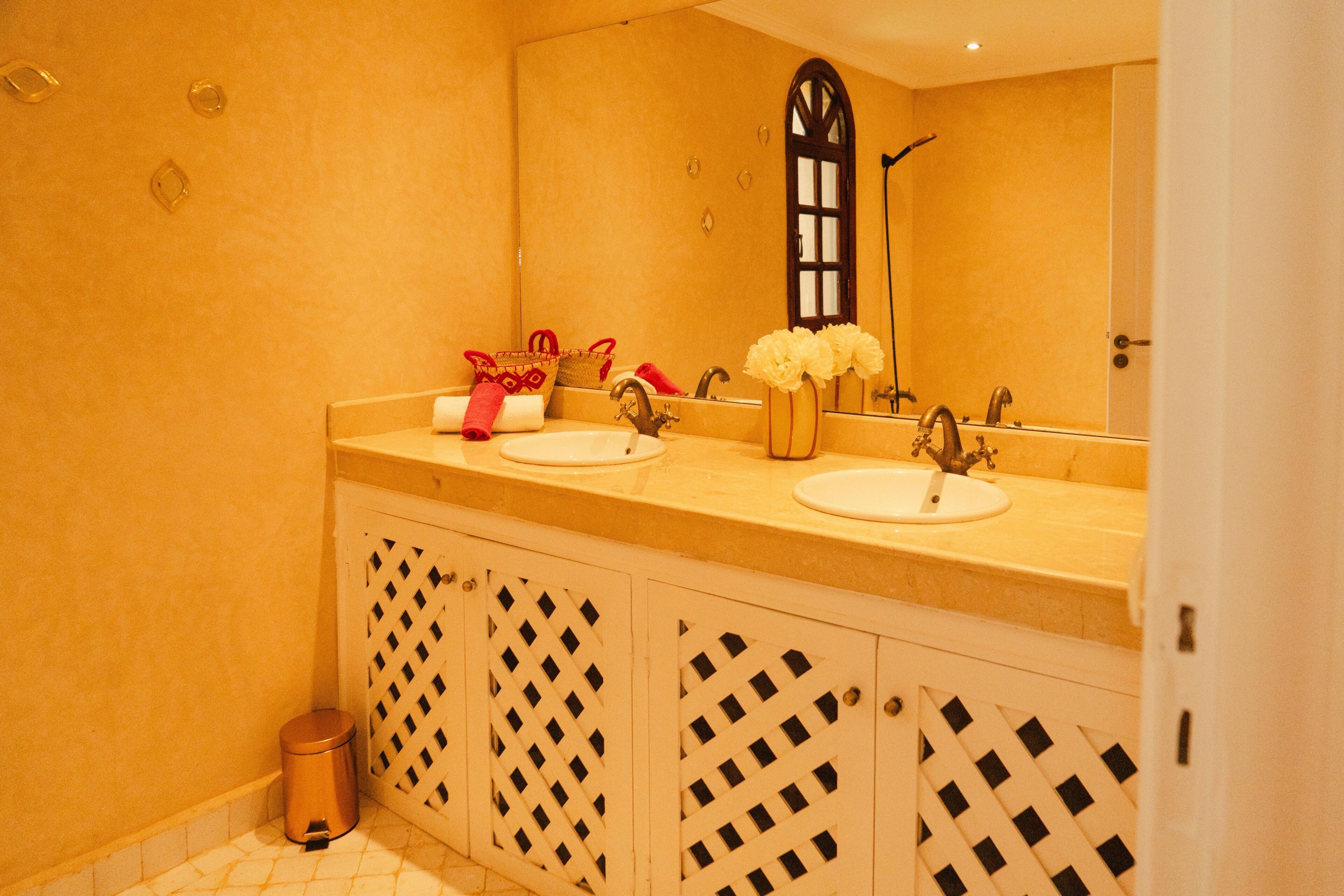 A bathroom with two sinks, a mirror, and a shower.