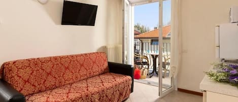 Departamento Confort, balcón | Área de sala de estar | Televisión