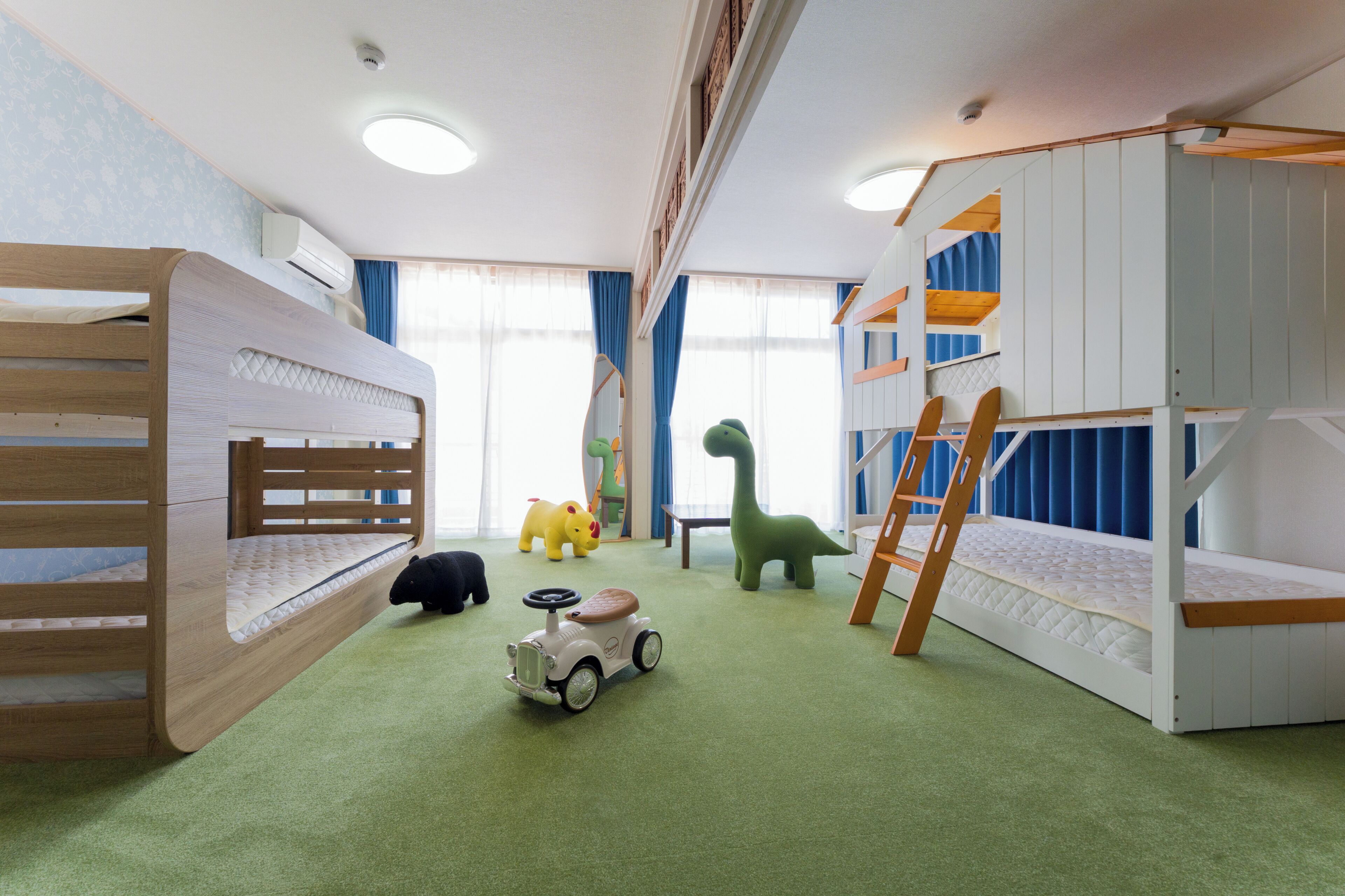 Um quarto infantil com beliches, um carrinho de brinquedo e um brinquedo de dinossauro.