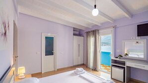 A hotel room with a bed, desk, and a view of the sea. - Blue Stay Hotel (Himarë)