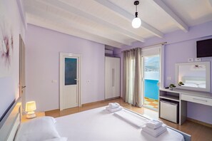 Ein Hotelzimmer mit Bett, Schreibtisch und Meerblick.