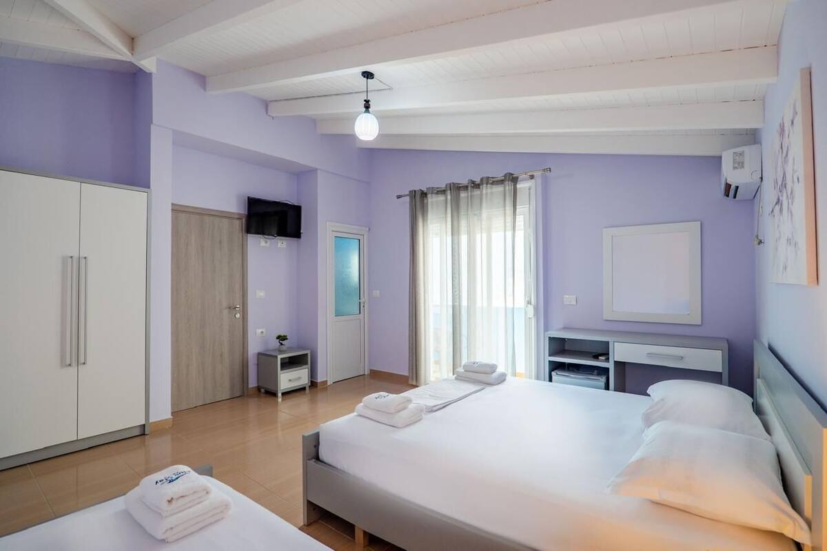 Un dormitorio con cama, armario, escritorio y televisor.