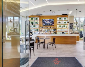 Eine moderne Bar mit Fernseher, Holztresen und Sitzgelegenheiten.