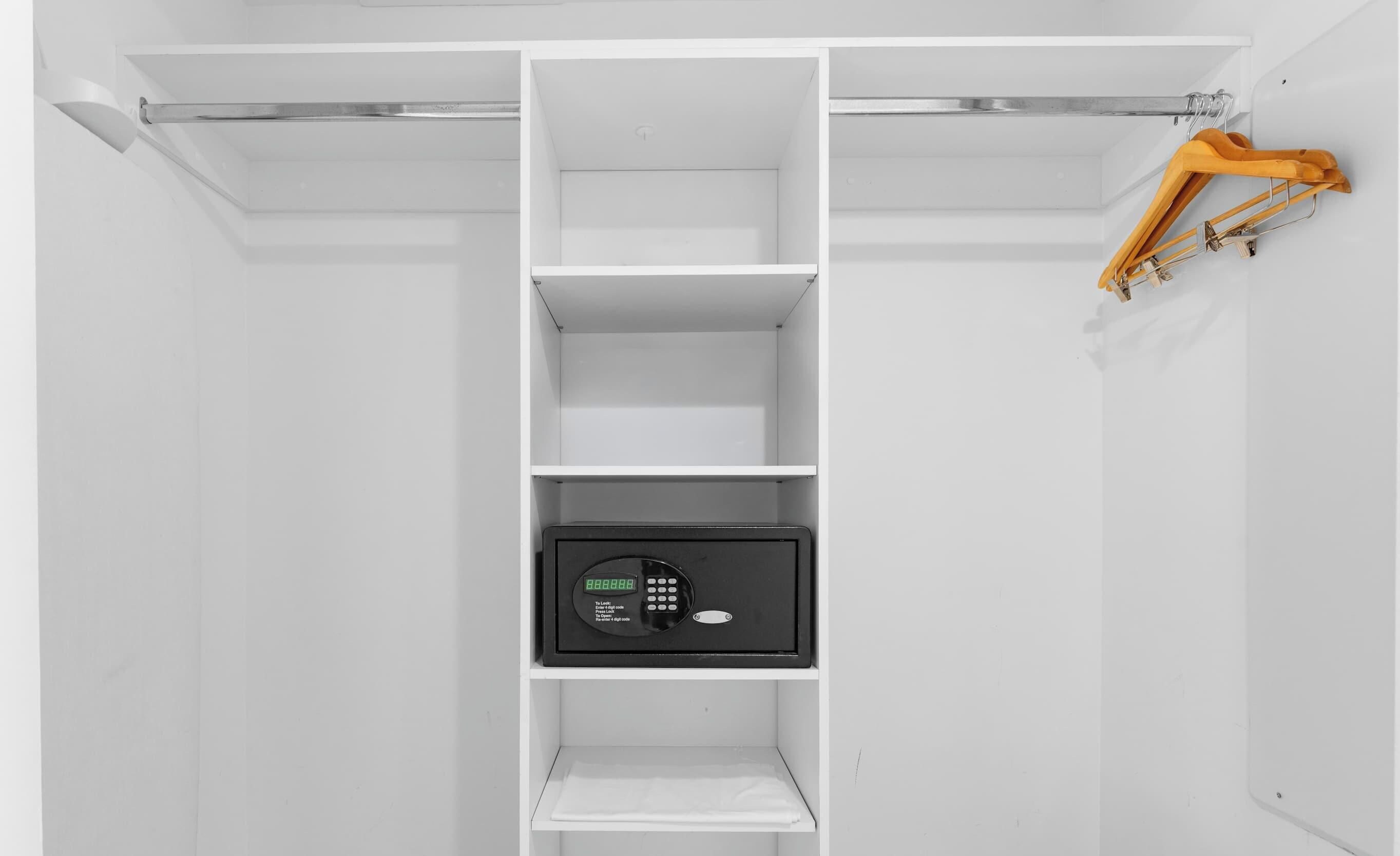 Une armoire blanche avec plusieurs étagères et un coffre-fort noir.