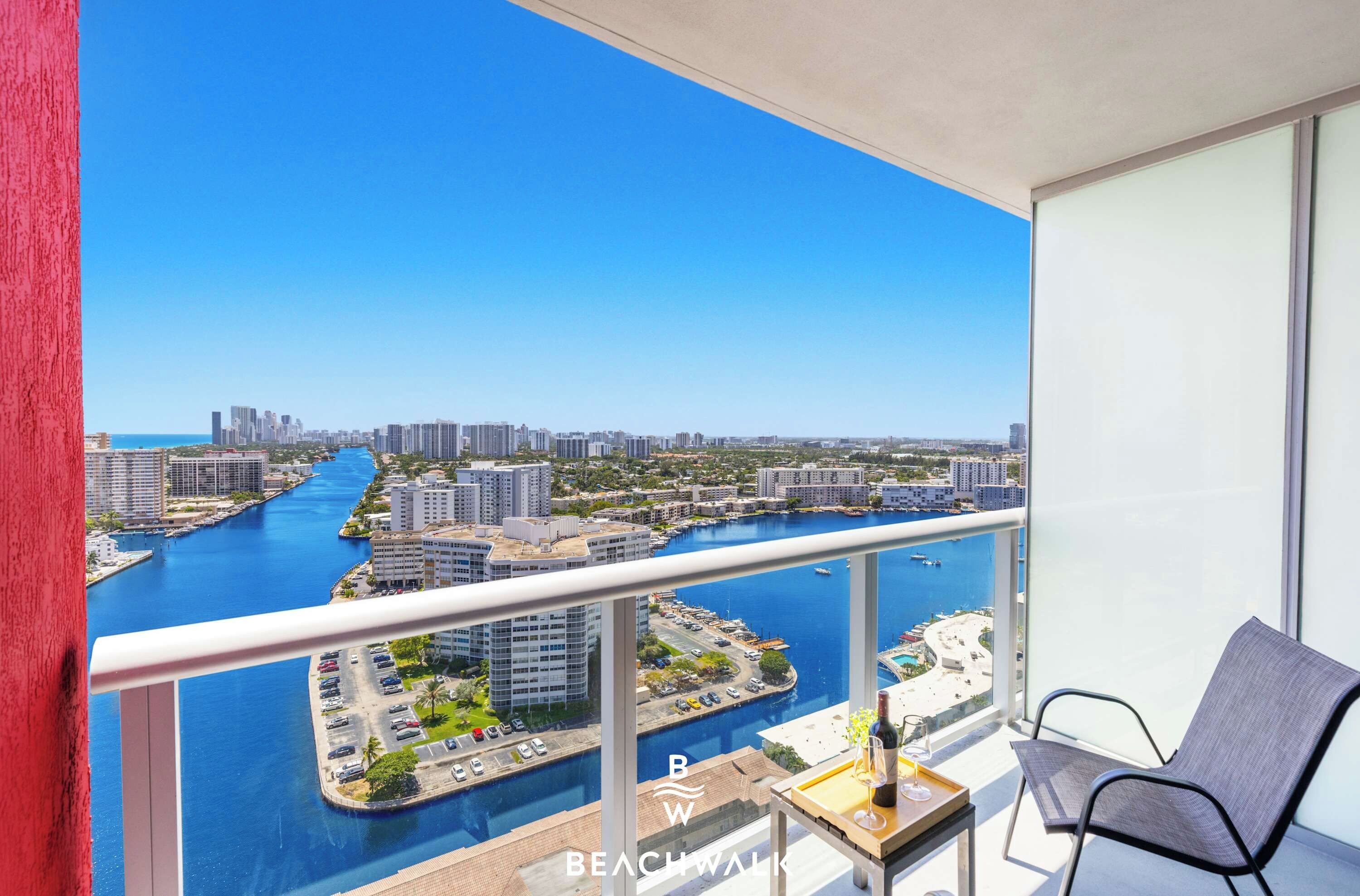 Un balcon avec vue sur un port de plaisance et sur le paysage urbain.