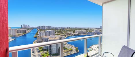 Un balcon avec vue sur un port de plaisance et sur le paysage urbain.