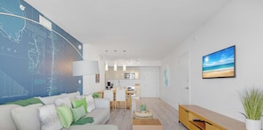 A modern living room with a large map on the wall, a dining area, and a kitchen. - Sunset View - Bright Apt - Bay View Fitness Center (Hallandale Beach)