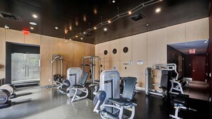 Un gimnasio con equipo de ejercicio, paredes de madera y un espejo grande.
