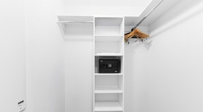 A white closet with a hanging rod and a safe. - Marina Views  2BR  Beachwalk Resort (Hallandale Beach)
