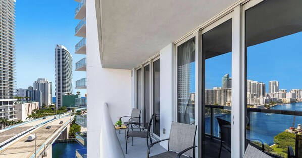 A balcony with a view of a city skyline and a body of water. - Spacious 2BR · Marina View at Beachwalk (Hallandale Beach)