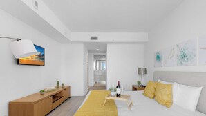 Un dormitorio moderno con cama, mesita de noche, lámpara y una obra de arte.