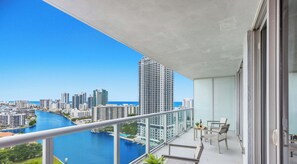 A balcony with a view of a city skyline and a body of water. - Waterway View 2BR · Beachwalk Resort (Hallandale Beach)