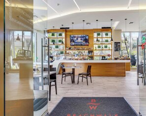 A modern bar area with a TV screen, wooden counter, and seating. - Stunning 1BR · Gym & Resort Pool (Hallandale Beach)