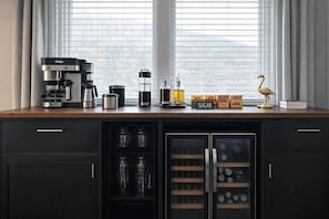 Eine Küche mit Kaffeemaschine, Zucker und einem dekorativen Vogel auf der Arbeitsfläche.