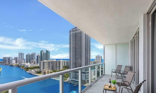 Een balkon met uitzicht op een stadshorizon en een waterpartij.