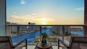 A balcony with a view of a cityscape and a river at sunset. - Elegant Studio w/ Intracoastal & Sunset Views (Hallandale Beach)
